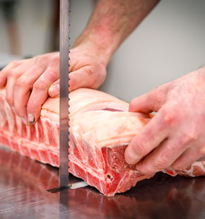 Meat being cut with a saw.