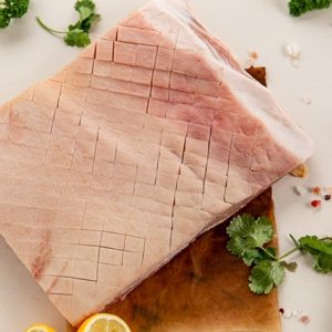 Pork belly roast surrounded by herbs and spices